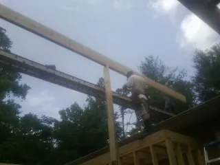 Carpenter setting a ridge beam over a new addition frame — Ice Dam Removal by Roofing Brothers in Amelia Court House