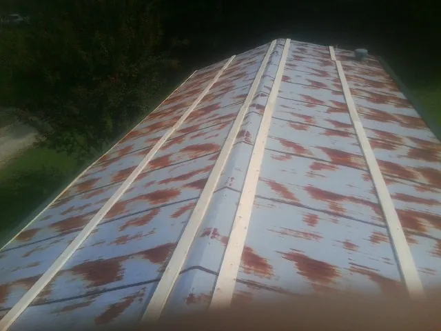 Rusted metal roof panels with new wood purlins before replacement — Storm Damage Roof Repair in Amelia Court House by Roofing Brothers