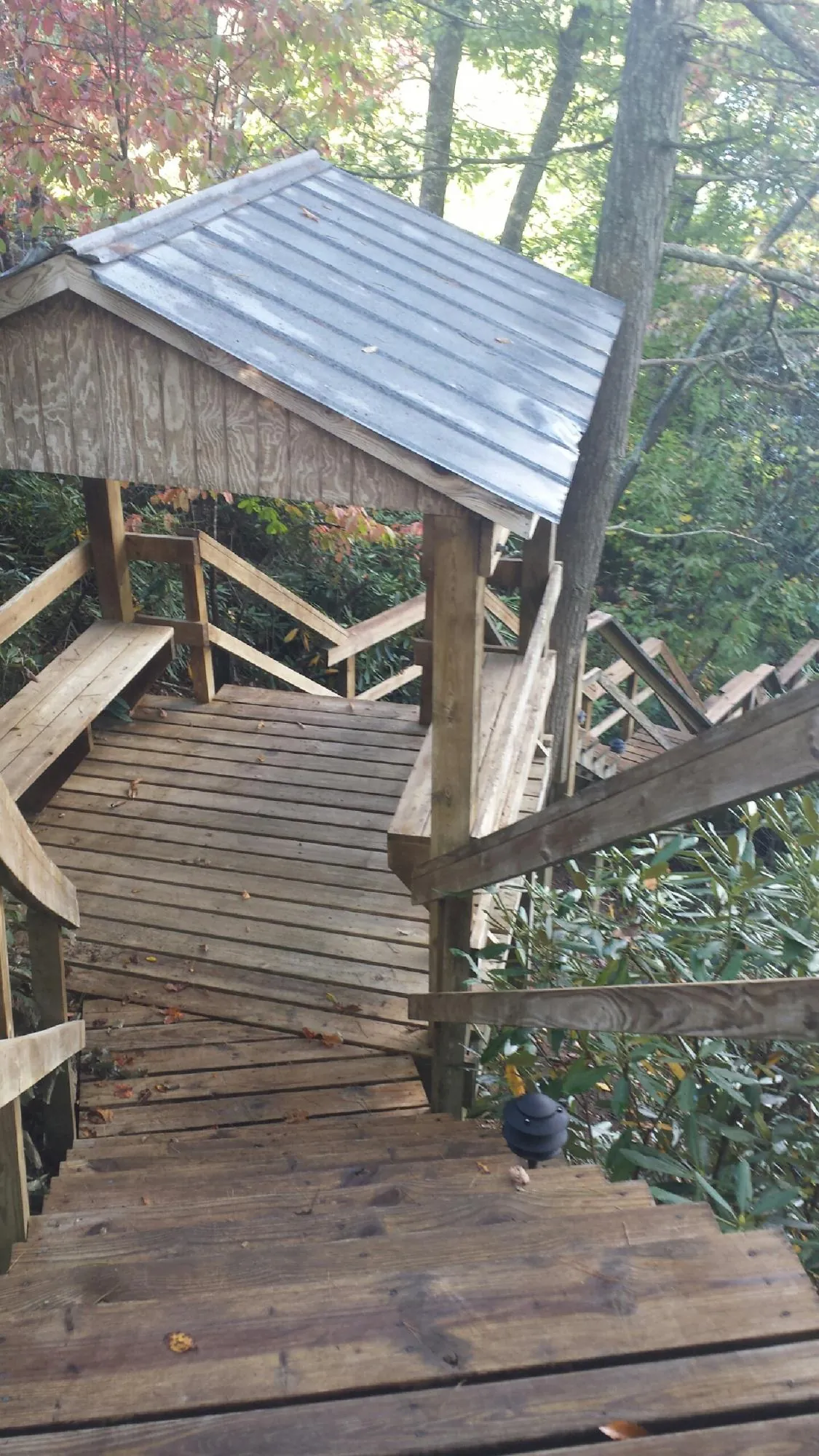Metal roofed shelter over wooden steps on a wooded walkway — Skylight Repair & Installation work by our crew in Amelia Court House