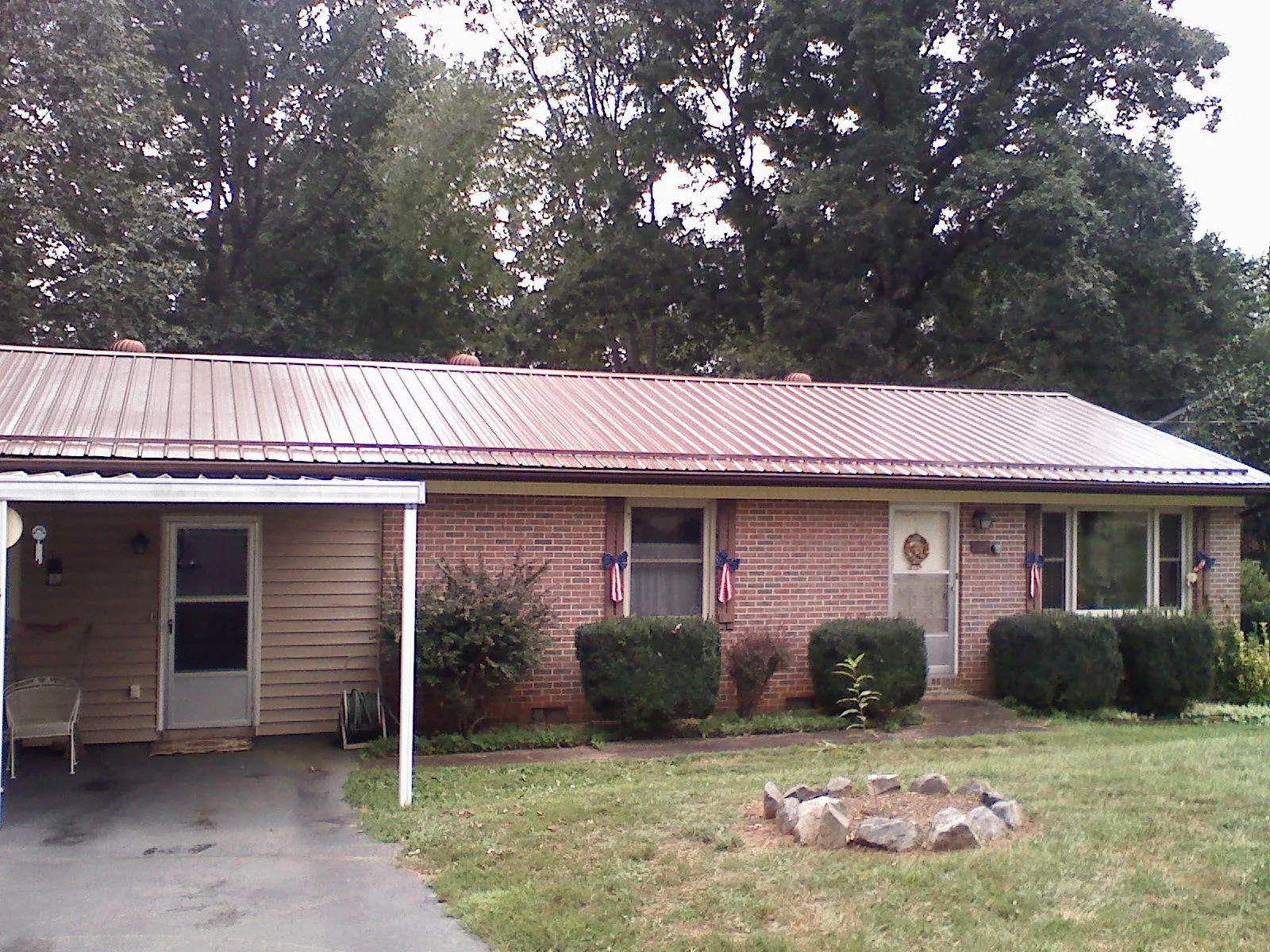 Bronze metal roof and carport on a brick ranch home — Roof Repair work by our crew in Amelia Court House